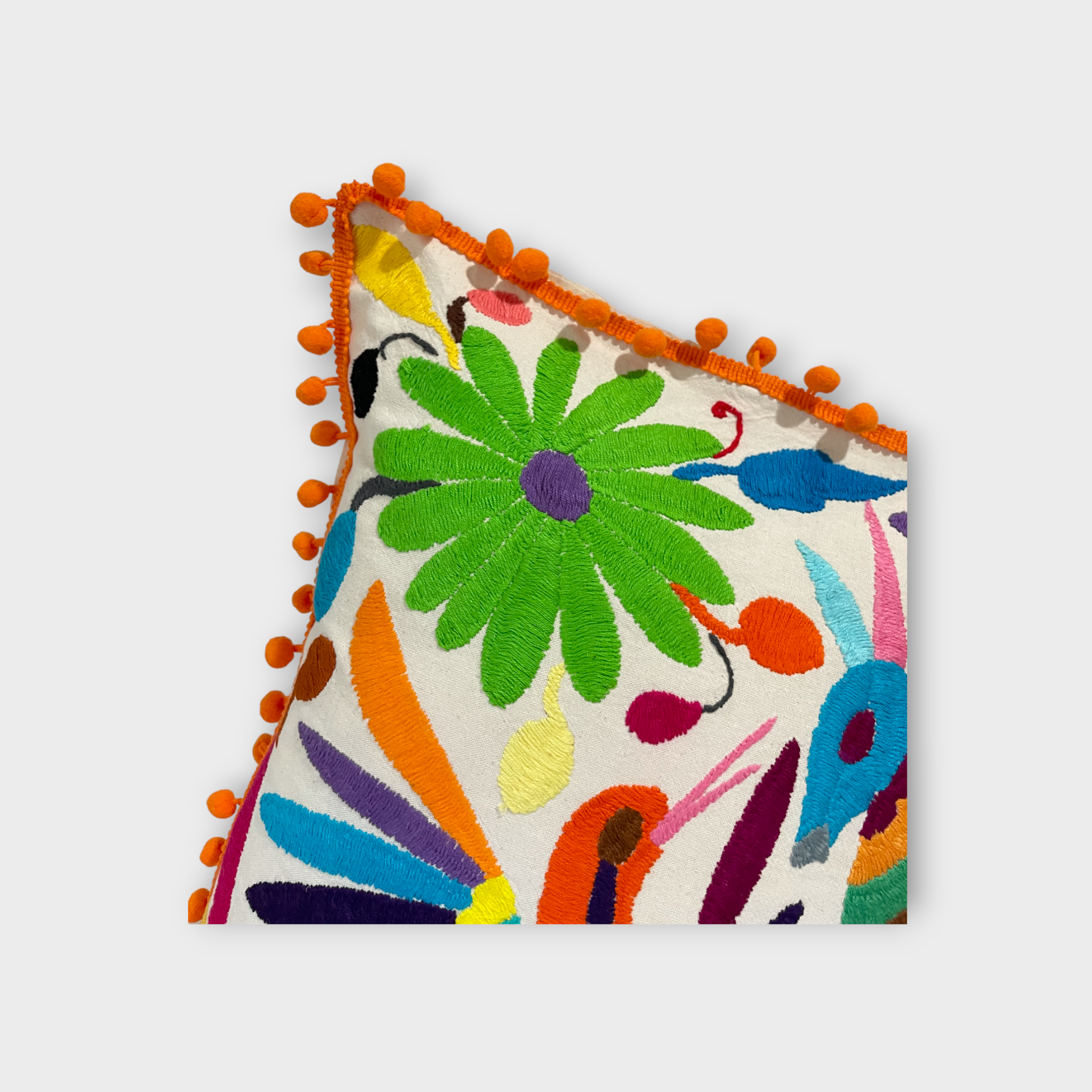 Otomi pillow cover with orange pompoms