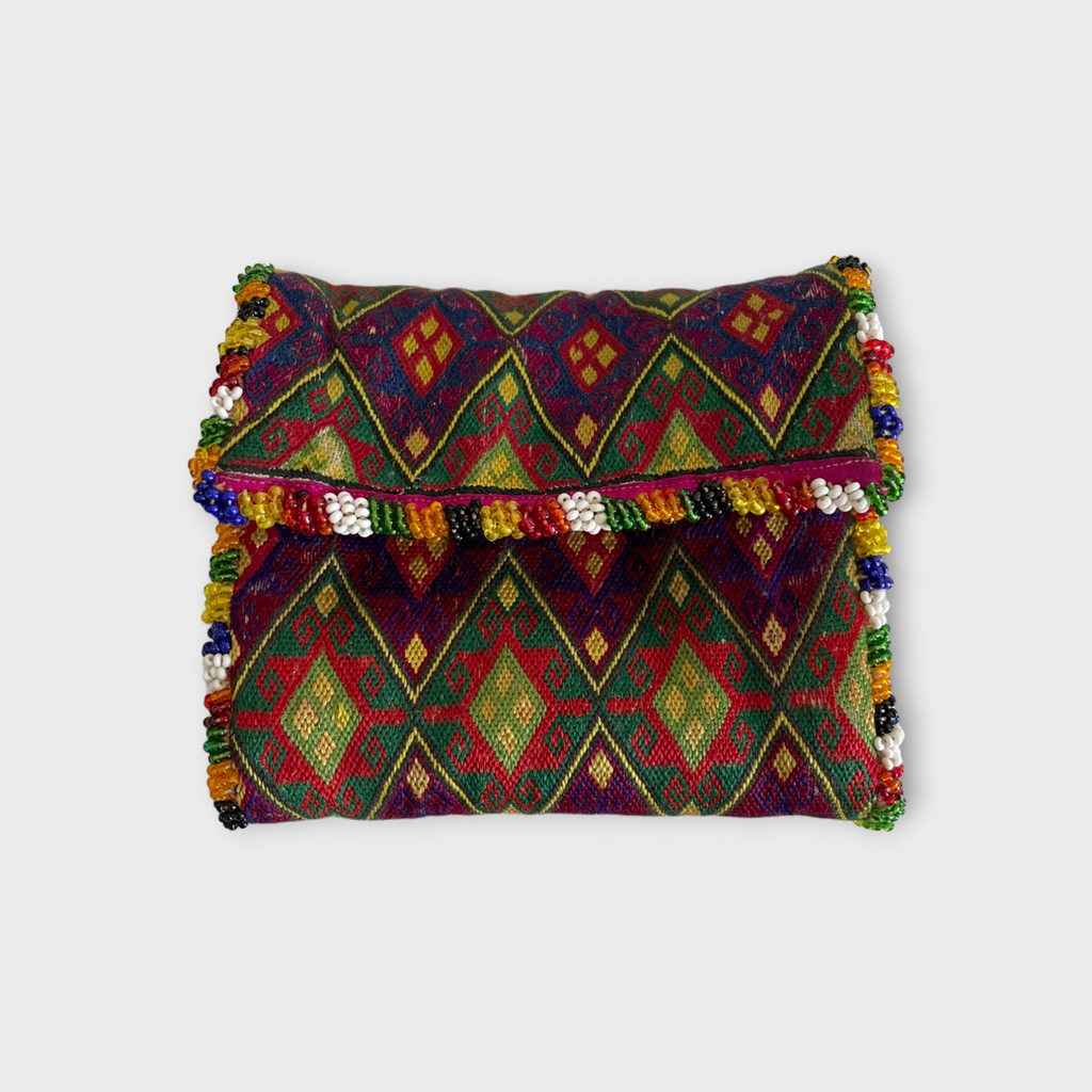 A vintage silk wallet with geometric diamond-shaped embroidery and colorful trim, featuring a floral pattern lining and snap buttons for closure.